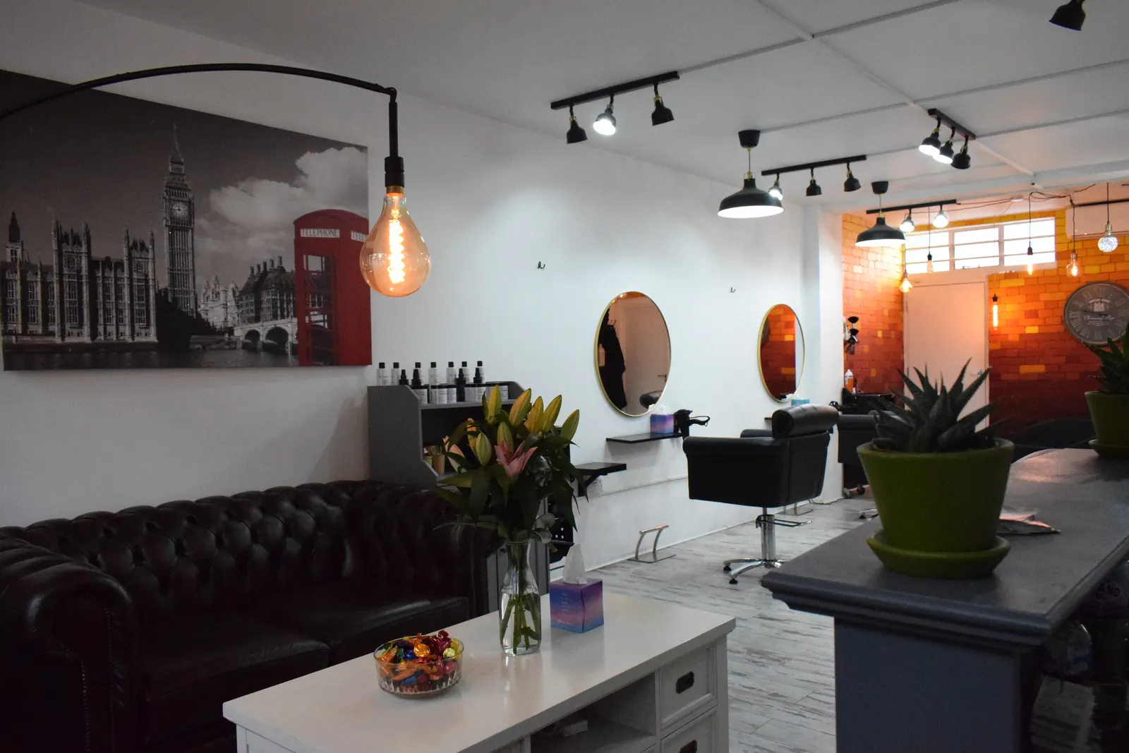 SEoneHair salon lounge with a London skyline print and styling stations