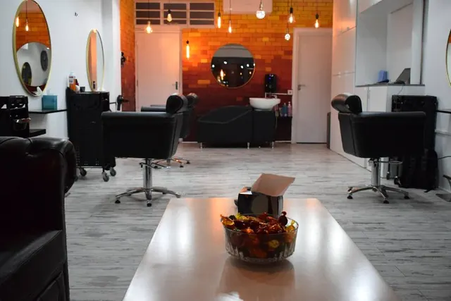 Wash station and styling chairs in front of the copper brick wall at SEoneHair